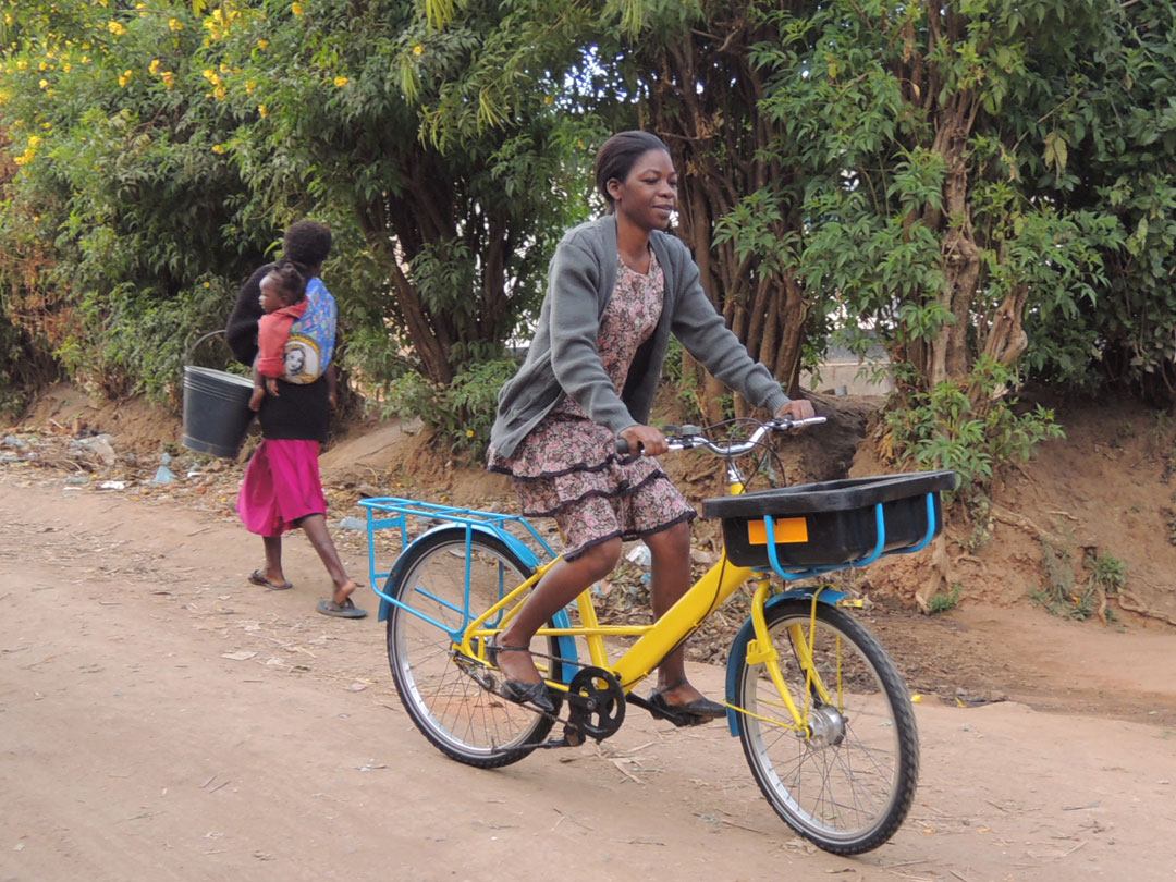 Beehive Enterprises worker Selina Masamba riding a refurbished Royal Mail bike.