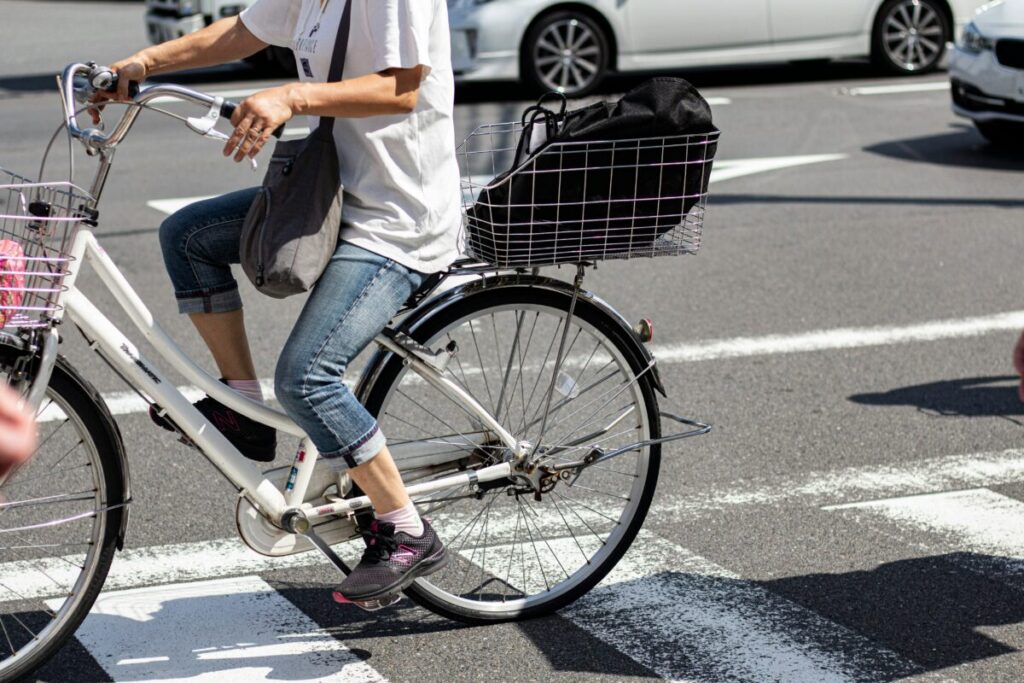 The image shows you someone riding a bike in Japan. This image conveys the need to have a Japanese Phone Number when trying to hire bikes in Japan.