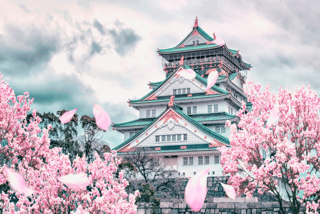 Osaka Castle surrounded by pink cherry blossom trees with petals falling in the wind at Osaka Castle Park, Japan