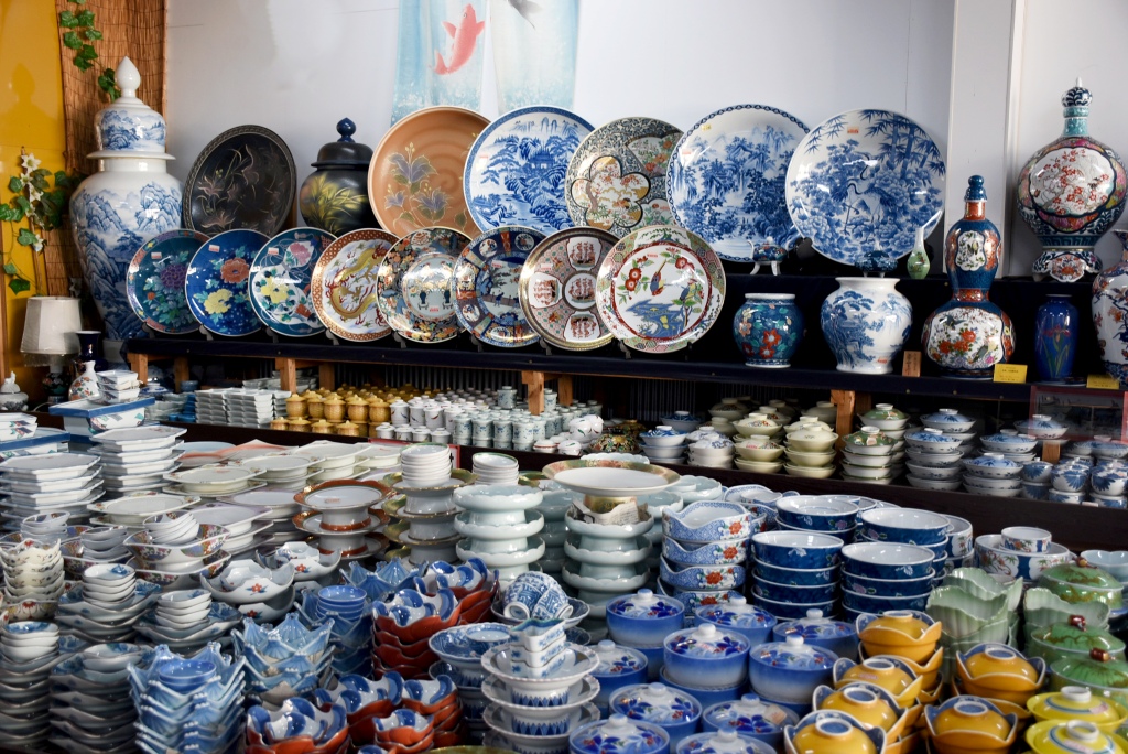 Shelves of Arita porcelain bowls, plates and vases displayed in a Japanese pottery shop.