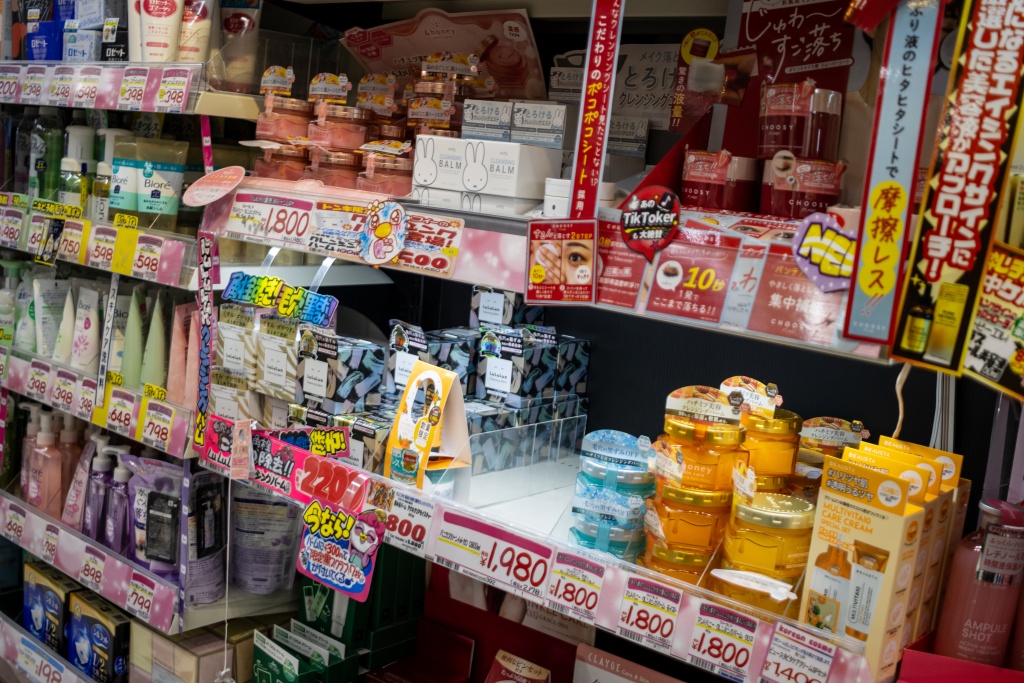 Shelves of Japanese beauty and skincare products in a Tokyo store, including creams, masks and haircare items.