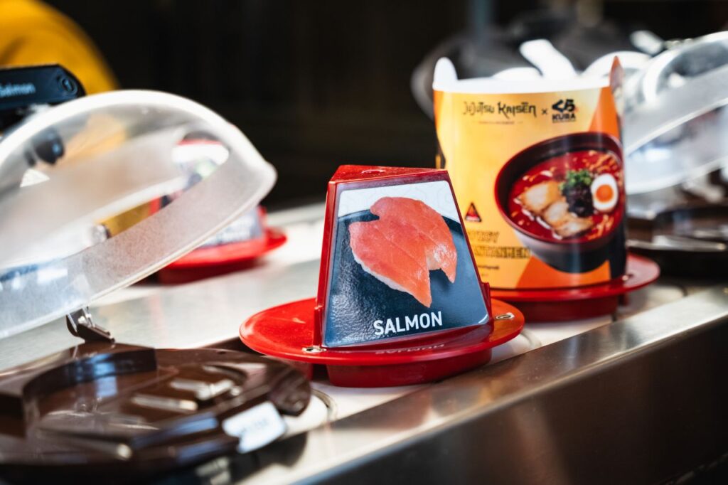 Salmon sushi menu sign on a red plate on a conveyor-belt sushi lane