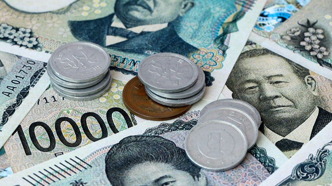 Japanese yen banknotes with stacks of 100-yen and 10-yen coins