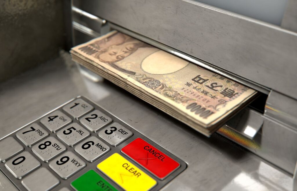 Traveller withdrawing cash from an ATM inside a Japanese convenience store
