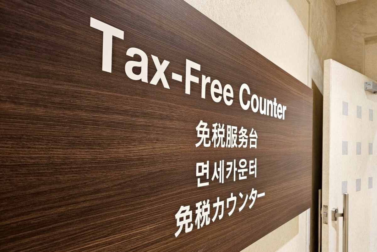 Traveller showing a passport at a Japanese shop counter during a tax-free purchase