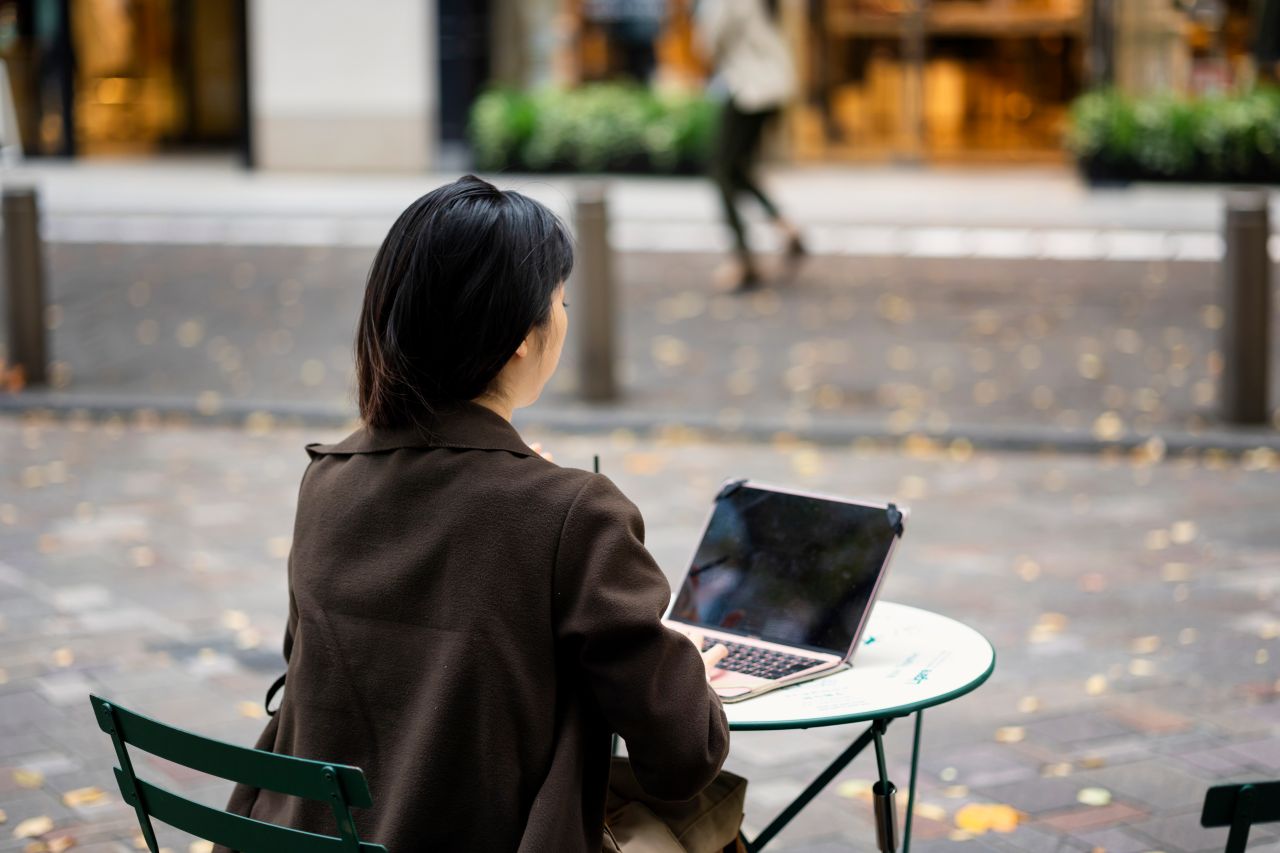 Remote worker with a laptop at a cafe window in Tokyo