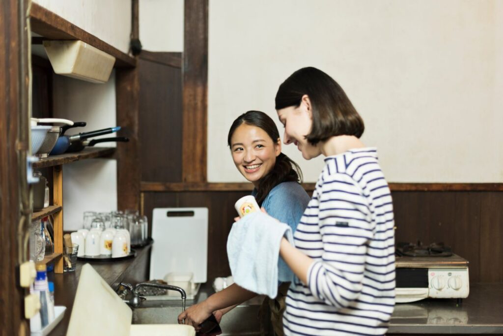 Two residents chatting in the shared kitchen of a share house